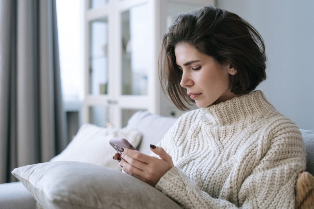 Person looking tired while using a dating app, representing dating burnout and online dating fatigue.